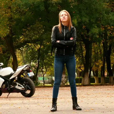 Portrait of a woman outdoors by a motorcycle